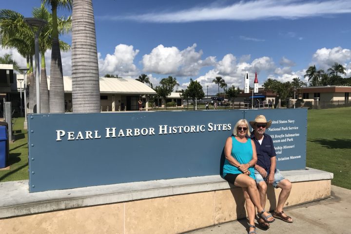 a man standing next to a palm tree