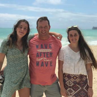 a woman standing next to a body of water posing for the camera