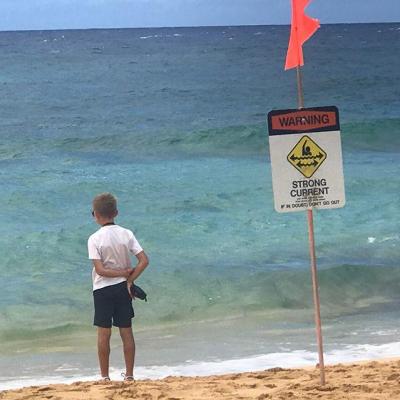 a man standing on top of a sandy beach next to the ocean