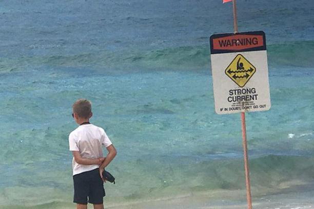 a man standing on top of a sandy beach next to the ocean
