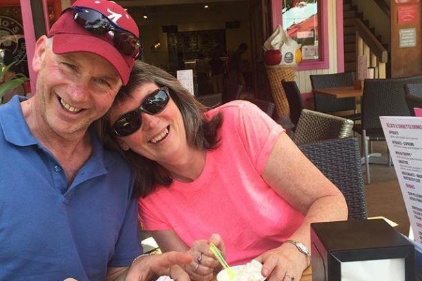 a man and a woman sitting at a table with food