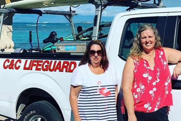 a group of people standing in front of a car posing for the camera
