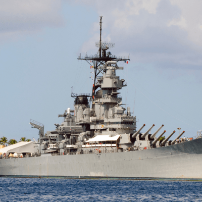 a large ship in a body of water with USS Missouri (BB-63) in the background
